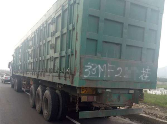 上路行驶的重型半挂车,挂车车厢后的放大号竟然是自己拿手写上去的.