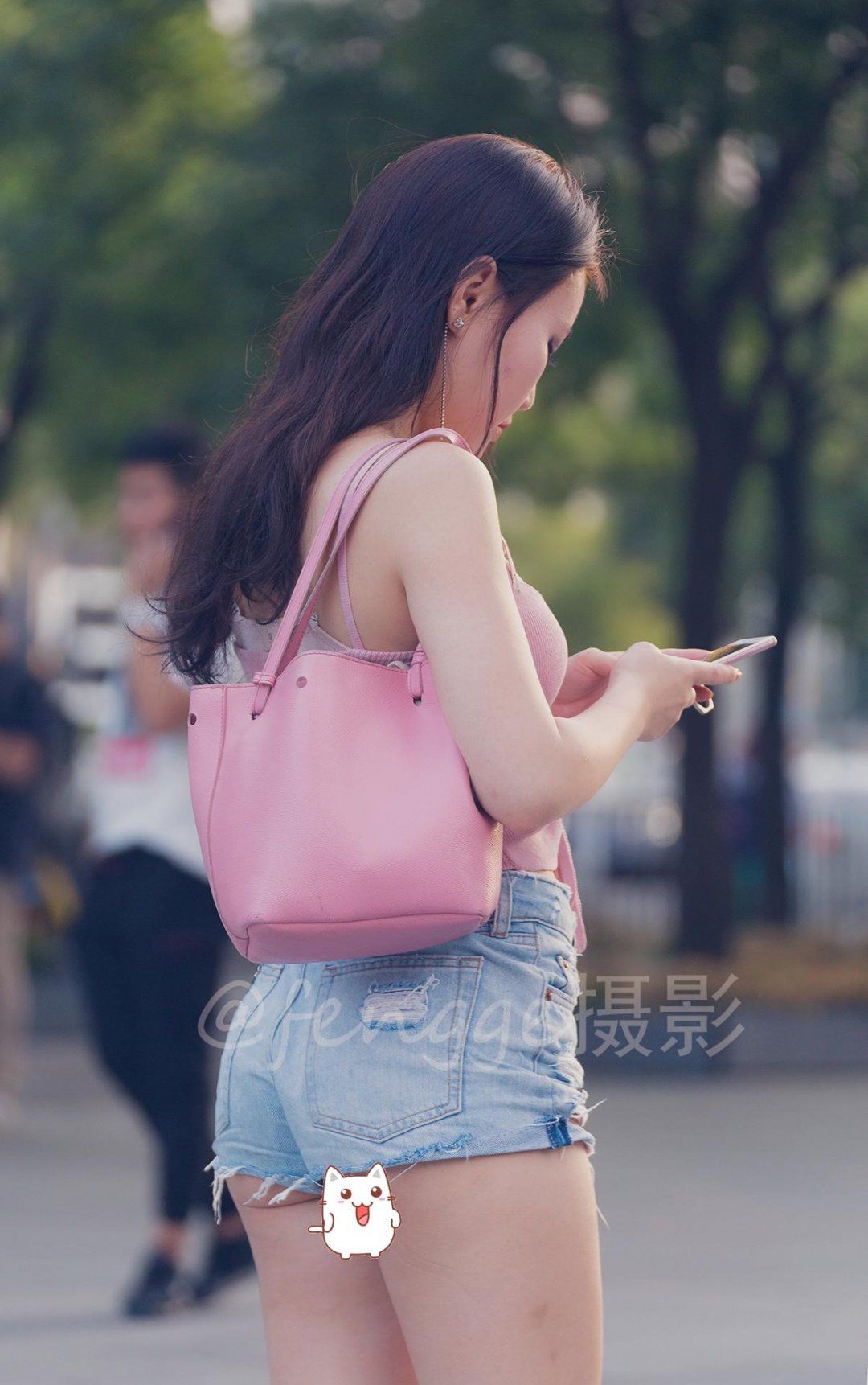 封面 那天傍晚,在北京三里屯太古里南区的南广场上,来了一个小姑娘,样子萌萌哒。 小姑娘人很好,很热情,遇到拍照是有求必应。不知道是粉色的包包里装了什么贵重的东西,以至于她弯腰放东西的时候,包包竟然从手里滑了下来,掉在了地上,看着真叫人心疼。 整理好包包,她很快从阴影中恢复过来,背好包包,专心的玩起了手机,嘴角还带着淡淡的微笑。 她留着一头长发,在夕阳的照射下,非常漂亮。她上身穿一件粉色针织吊带背心,胸前做了褶皱和系带的设计,显得很可爱;下身穿了一条蓝色牛仔热裤,热裤非常短,裤脚高的不能再高