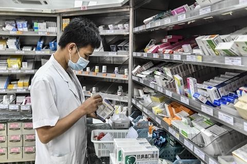 2017年7月15日,广东一医院药房内,工作人员为就诊的市民配药.