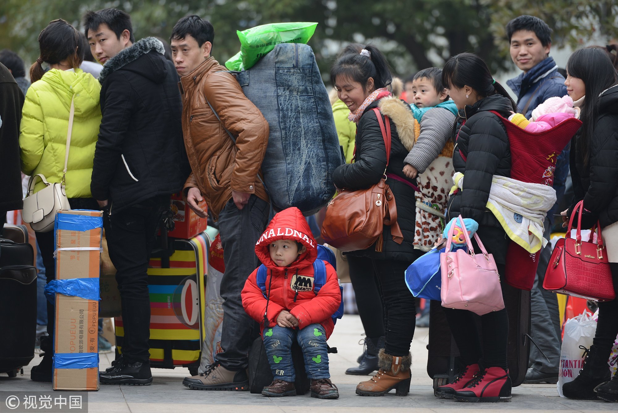 2015年02月04日，浙江金华，春运首日，义乌火车站春运首日发送乘客达22570。等待上车的外来建设者们或背着重重行囊或拖家带口，个个归心似箭。图/视觉中国