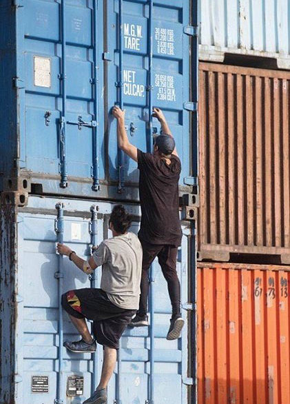 跑酷运动员攀爬铁箱。