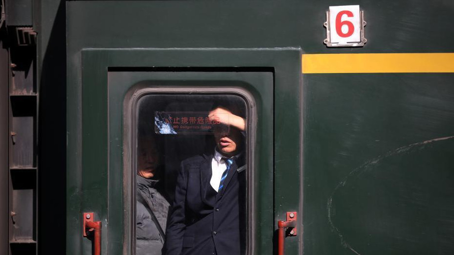 1月24日，透过停靠在南京火车站的列车车窗，车内的乘客或站、或坐、或沉思。随着春节的临近，越来越多的民众带上行李，踏上旅途。