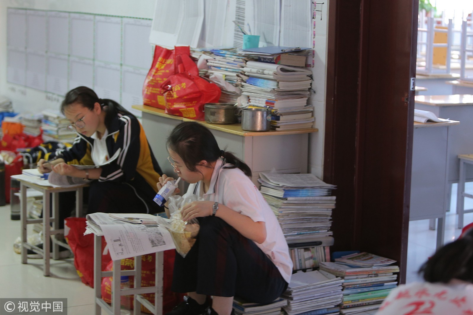 河北衡水二中教学楼楼道里，中午放学后，学生在楼道里边吃饭边学习。