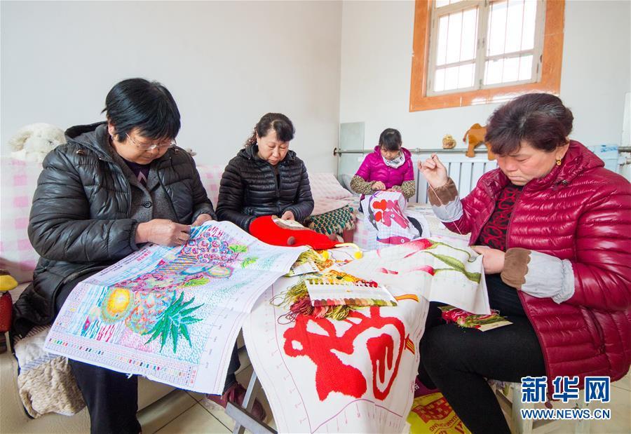 3月8日,武邑县清凉店镇鲍贤兰村农民在加工制作手工十字绣.