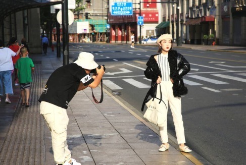 7月30日报道，7月30日，上海，清晨，模特在南京东路外滩路口拍摄时装照片。
