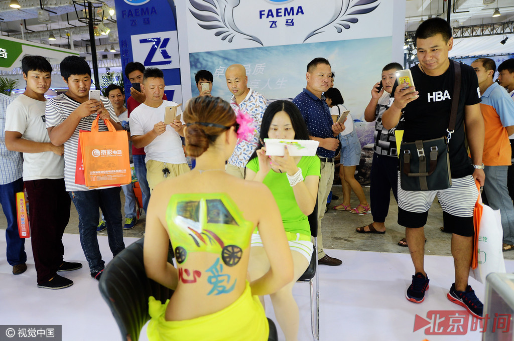 济南老年代步车展上演人体彩绘维秘秀。