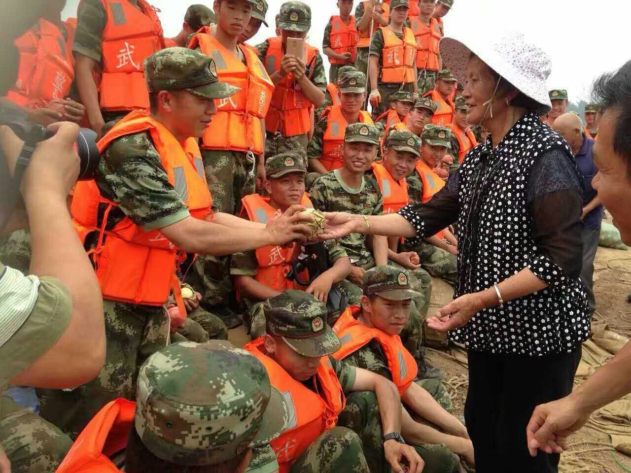 2016年7月,在安徽宿松抗洪大堤上,村民王翠连续一周自发给在此地抗洪抢险的武警8691部队官兵送上自家种的梨。赵再昌摄