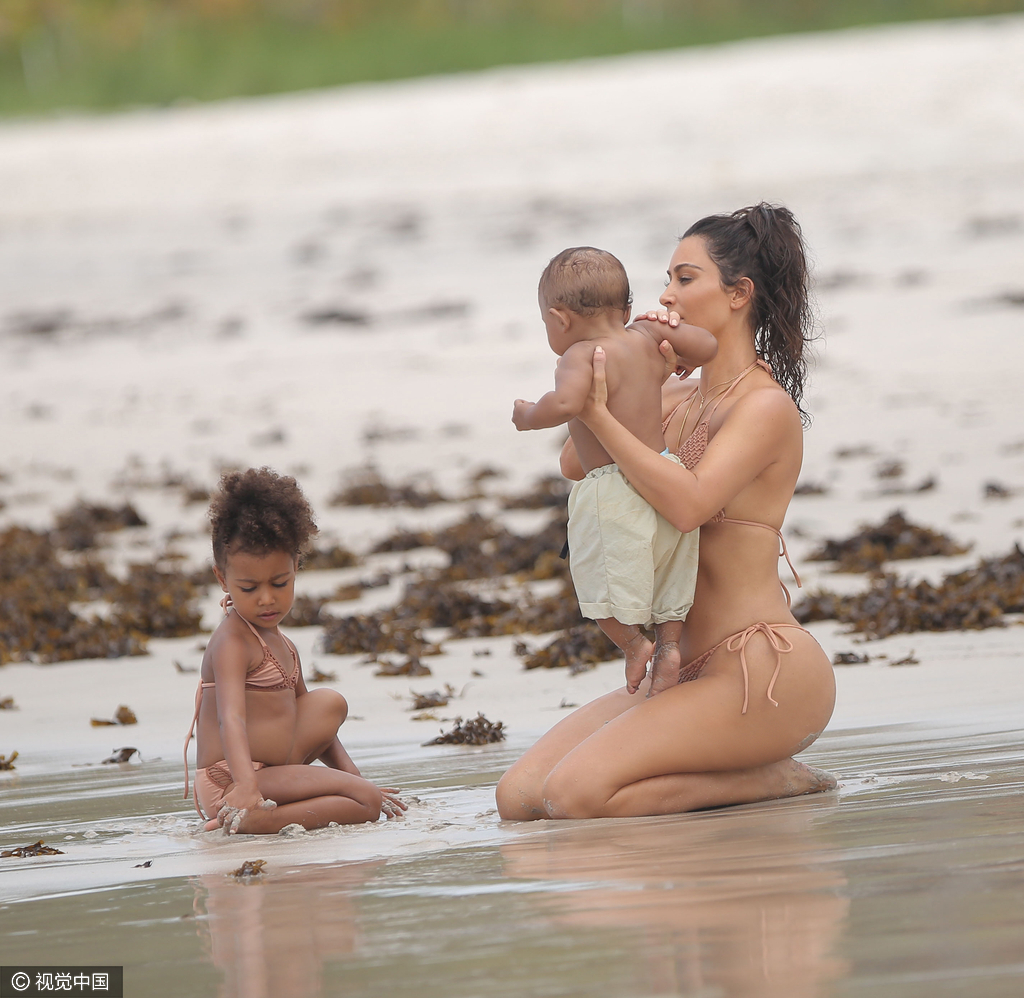 当地时间8月18日,金·卡戴珊(Kim Kardashian)带女儿小西北和儿子沙滩玩耍,卡戴珊身穿裸色系带比基尼,女儿与妈妈同款可爱十足,在沙滩上卡戴珊全程呵护幼子母爱爆棚,然而抢镜的还是翘臀。图为卡戴珊跪坐沙滩。