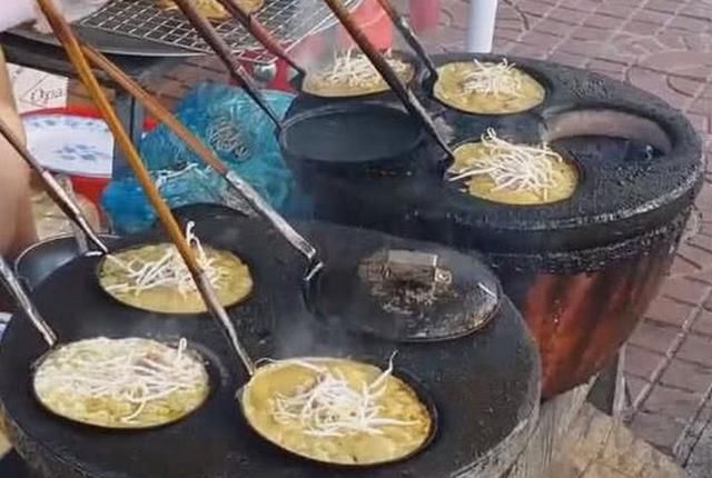 年轻女子在街边卖小吃一人掌9勺,生意非常的火爆