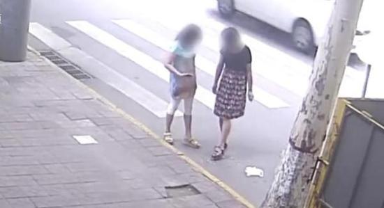 西安两城管街头撒烟头还拍照 官方:调离工作岗