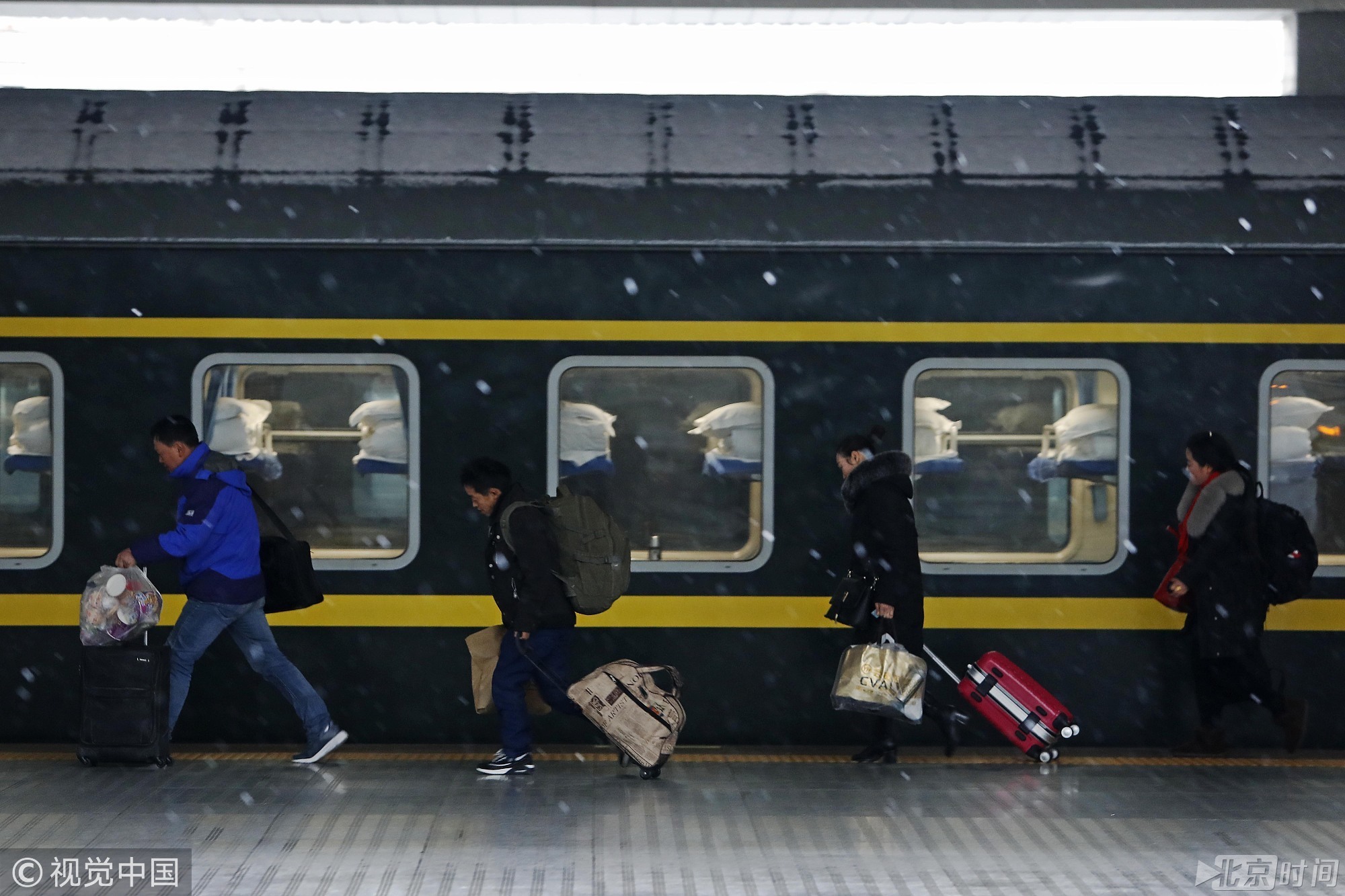 2018年1月25日，上海，旅客们背着行李冒雪在铁路上海站乘坐火车前往中国各地。上海中心气象台25日12时43分发布暴雪黄色预警信号：预计25日下午到26日凌晨上海市累积降雪量将达6-10毫米。此前，上海中心气象台9时53分继续发布道路结冰黄色预警信号。殷立勤/摄