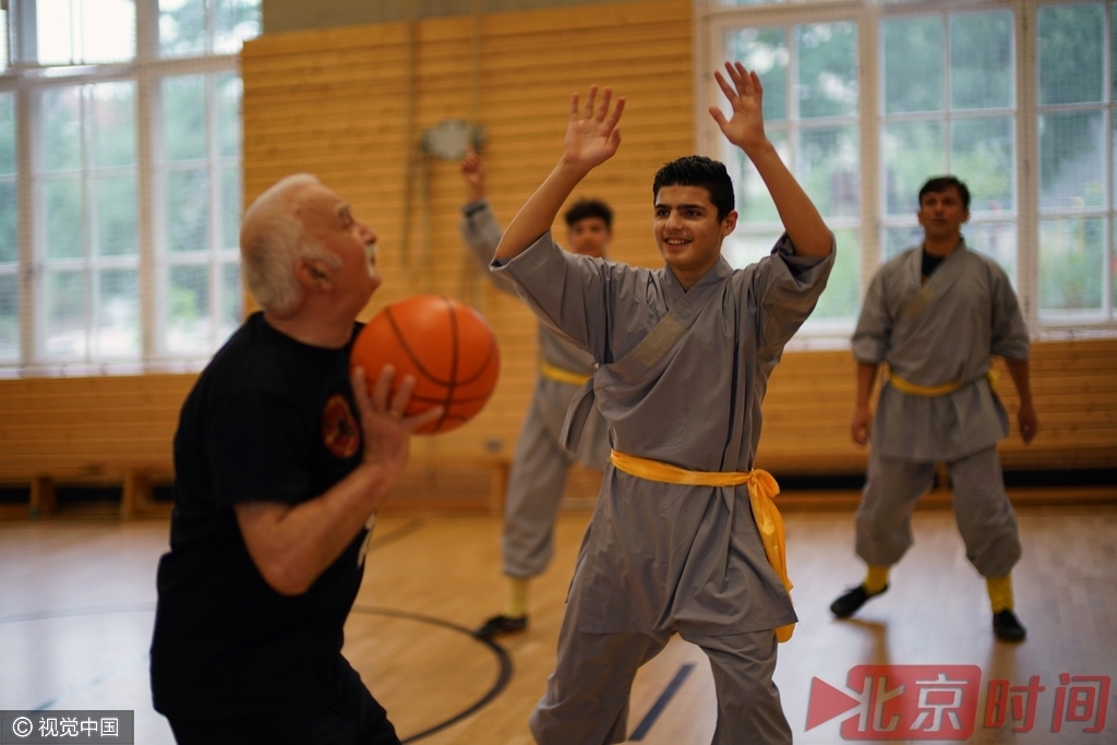 少林文化协会的会员们一起打篮球为武术训练热身，2015年来到德国的未成年叙利亚难民默罕默德试着断球。