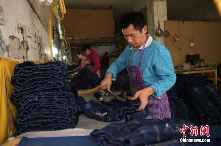 成都郫都区安靖镇土地村某服装加工厂内工人师傅正在赶制儿童服装。