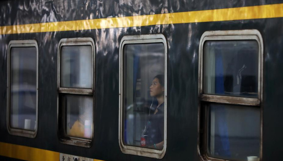 1月24日，透过停靠在南京火车站的列车车窗，车内的乘客或站、或坐、或沉思。随着春节的临近，越来越多的民众带上行李，踏上旅途。