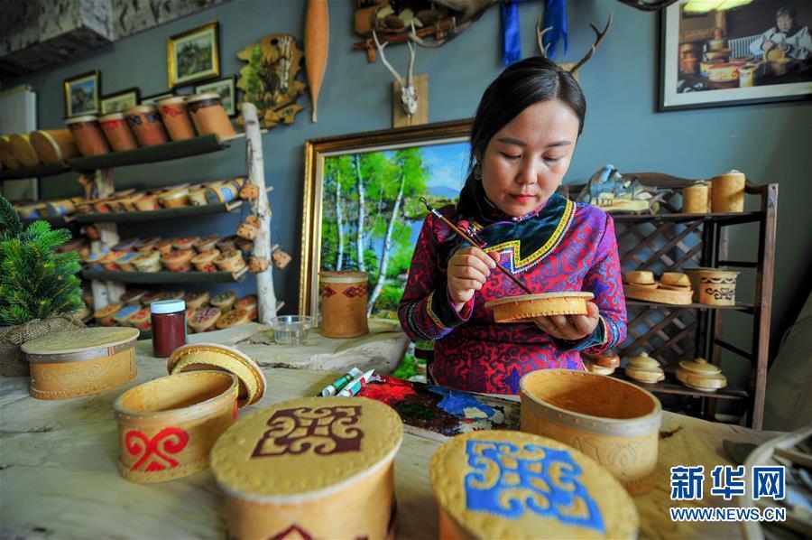 自治旗鄂伦春自治旗阿里河镇居民吴楠在自己家的工艺品店内绘制传统的鄂伦春族桦树皮制品(6月29日摄)。
  新华社记者 连振 摄