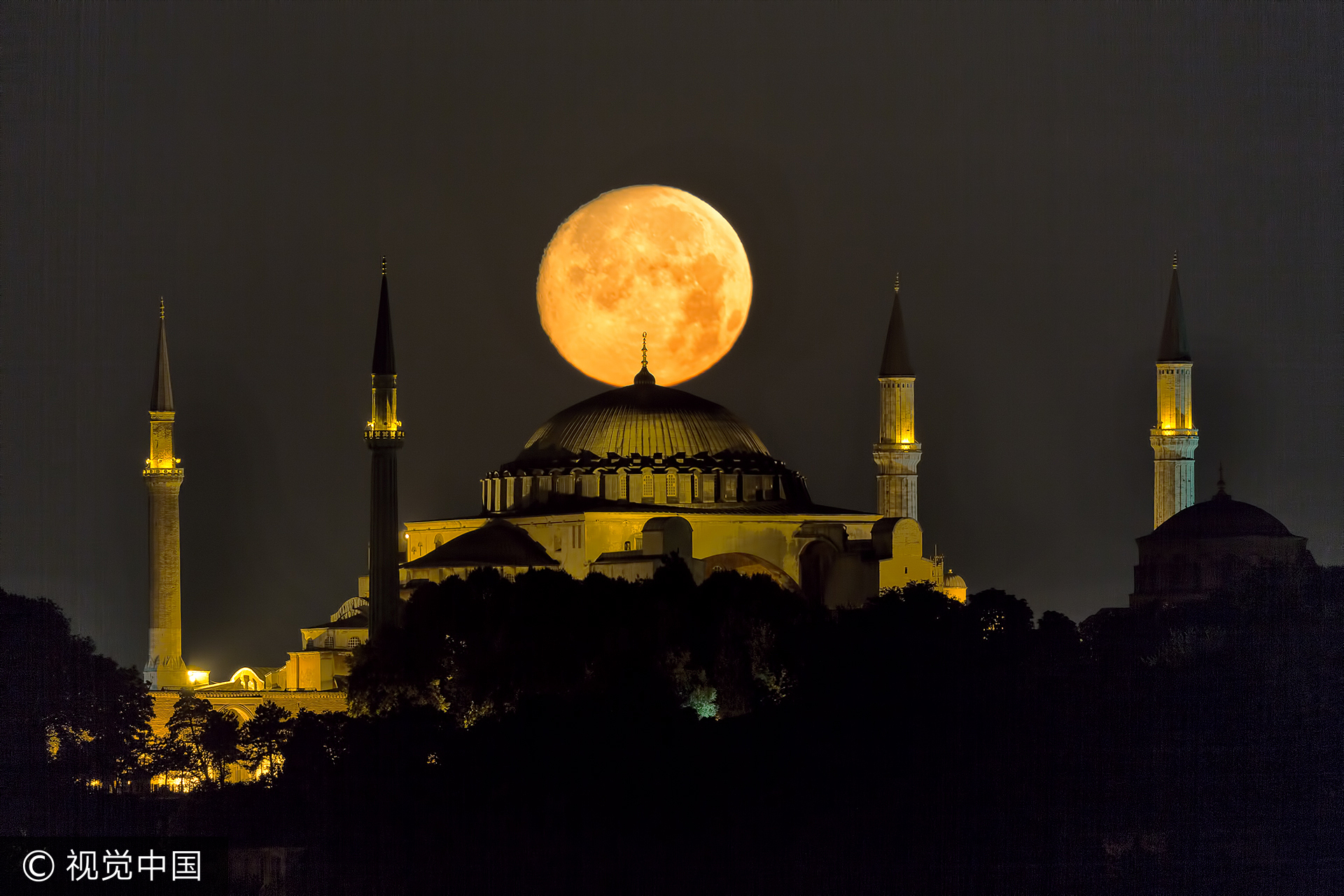 当地时间2014年7月11日，土耳其伊斯坦布尔，一轮明月在清真寺的上方构成了如画般的美景。时值斋月，人们可以看到月亮在此期间由新月变为满月的过程。