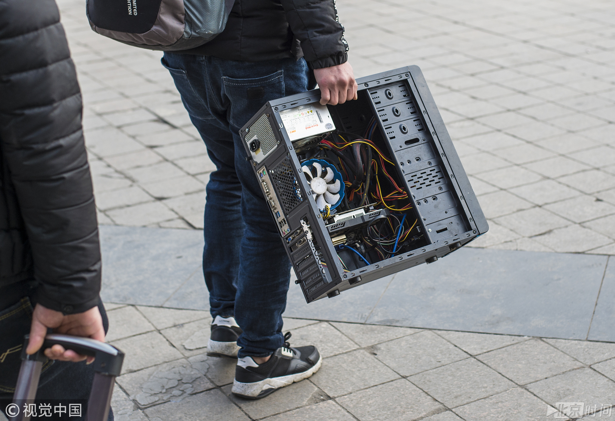 2018年2月13日，四川成都。随着春节日益临近，回家的旅客也开始加快步伐，一名旅客随身携带一台电脑主机。袁可佳/摄