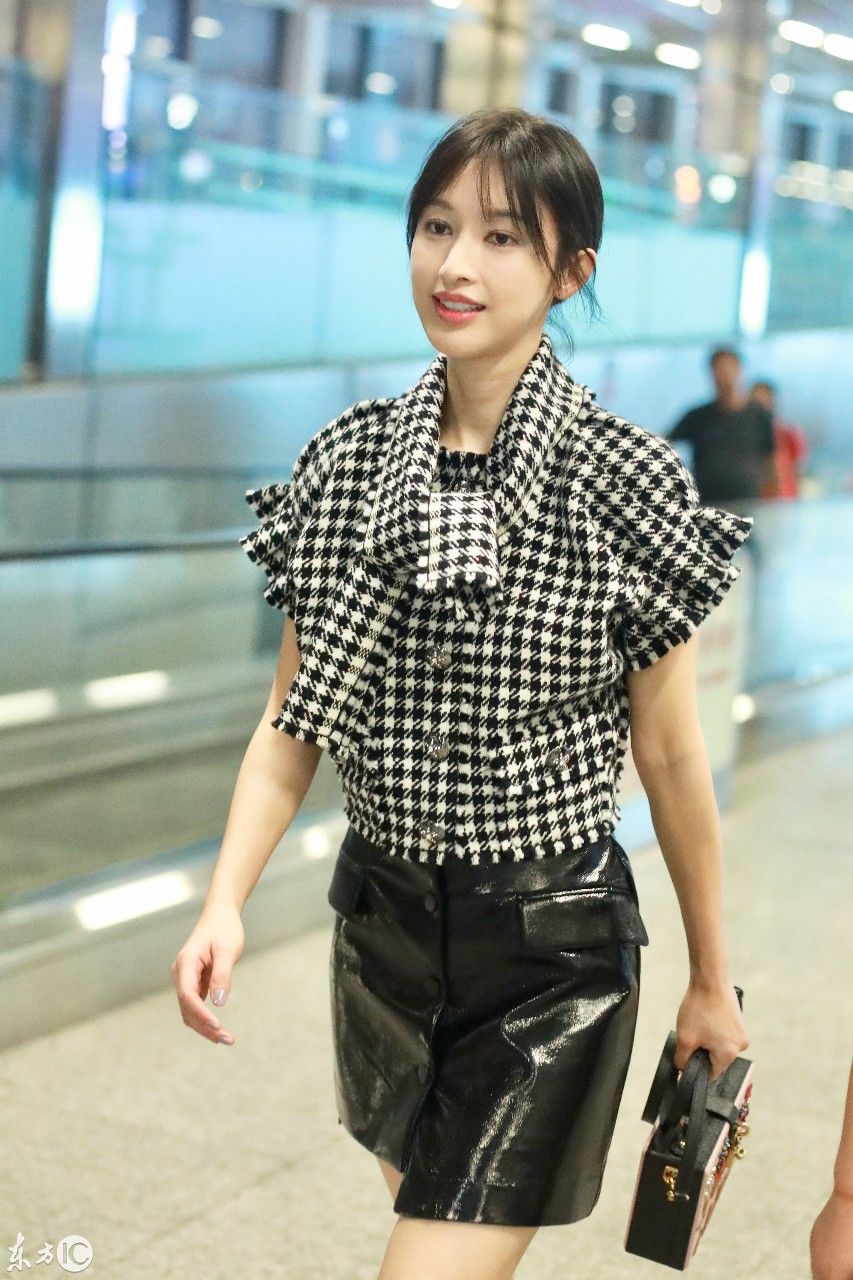 张俪现身机场,黑白格子上衣配黑色皮裙,简单又