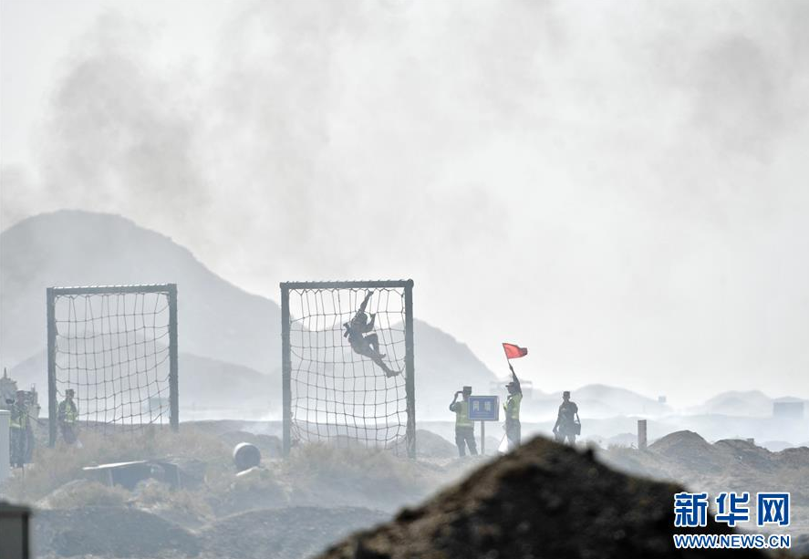 8月2日,“安全环境”核生化侦察组项目单车赛的参赛队员在翻越网墙。