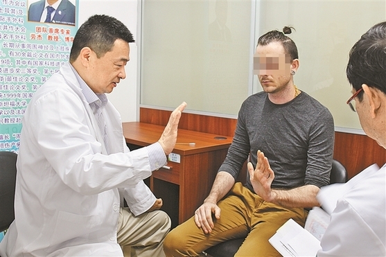 劳杰教授在为美国小伙子检查手臂.