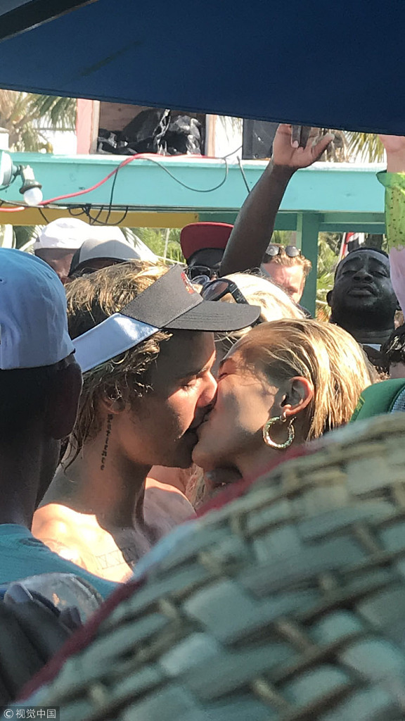 当地时间2018年7月9日，巴哈马，贾斯汀·比伯（Justin Bieber）和海莉·鲍德温（Hailey Baldwin）在海滩庆祝他们订婚。比伯赤裸上身露纹身，和海莉·鲍德温在人群中热吻，高调示爱。海莉·鲍德温激动飙泪。