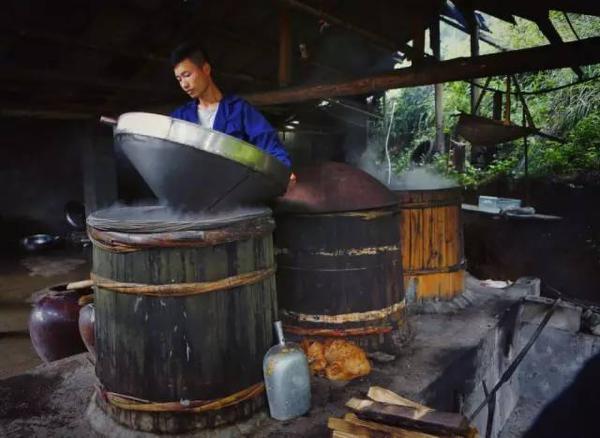 扪岱村村民为邓超超(右)端上一碗自家酿的苞谷烧.