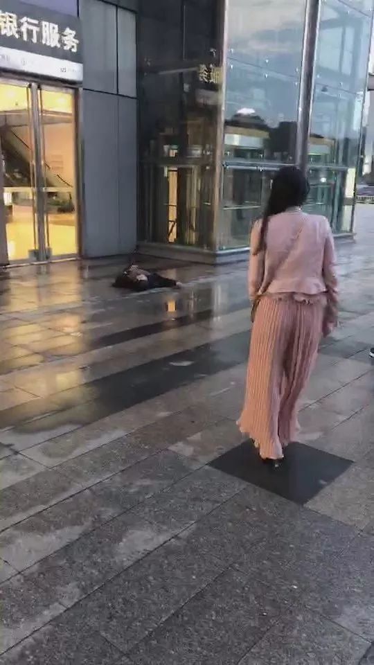 女子走路玩手机,天上突然掉下大活人