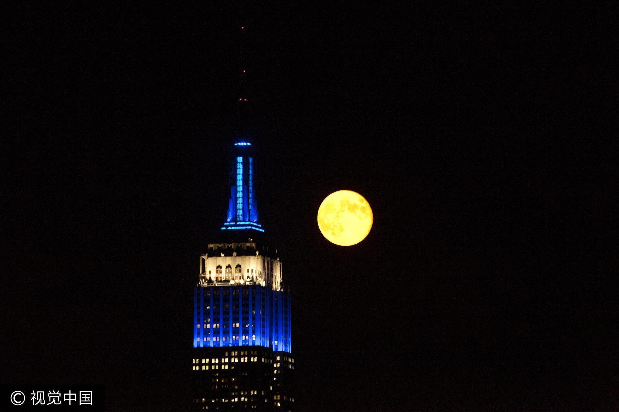 当地时间2013年8月21日,美国霍博肯,纽约天际线之上一轮满月升起,形成一道绝美的夜景。