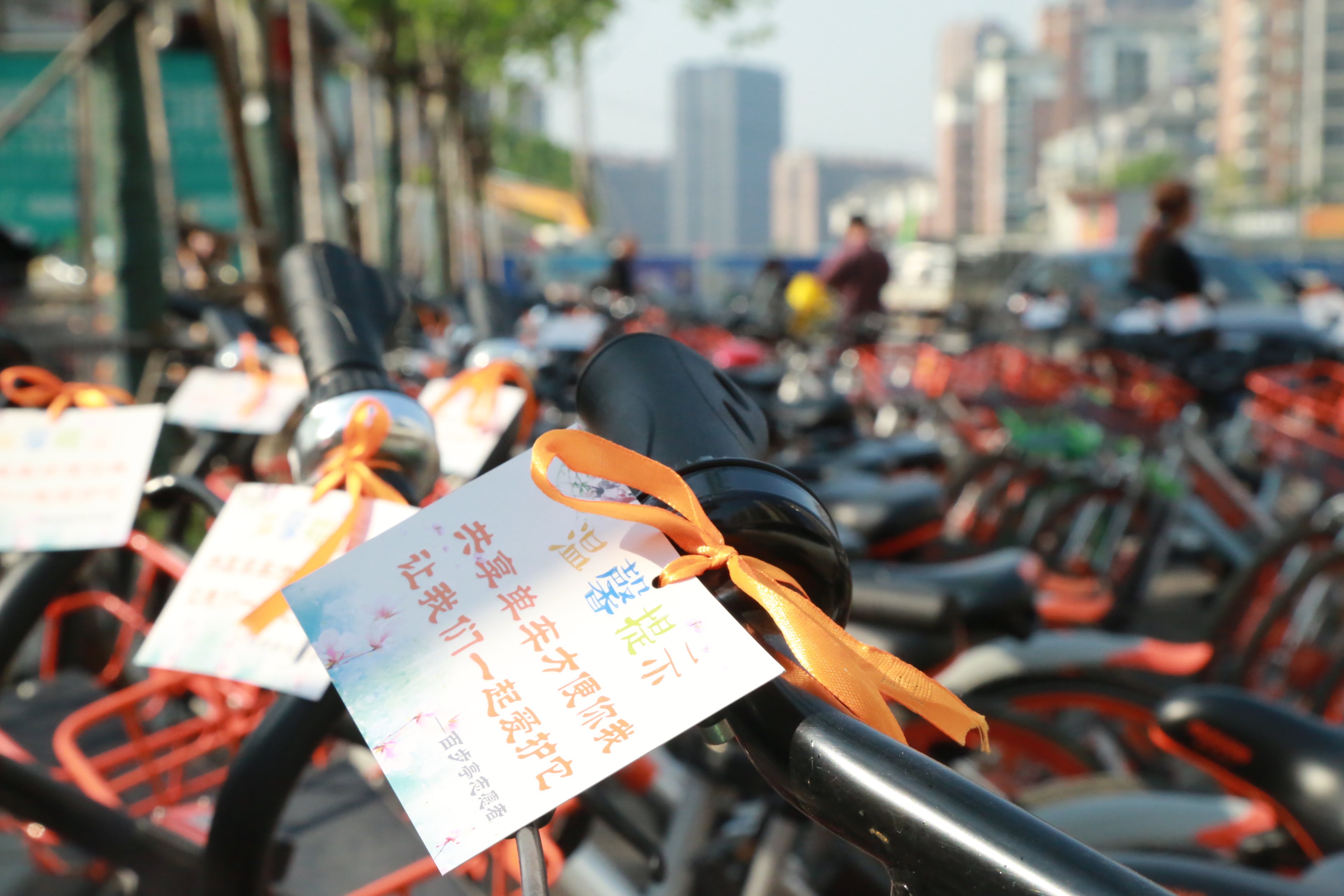 武汉志愿者为共享单车系上文明标语