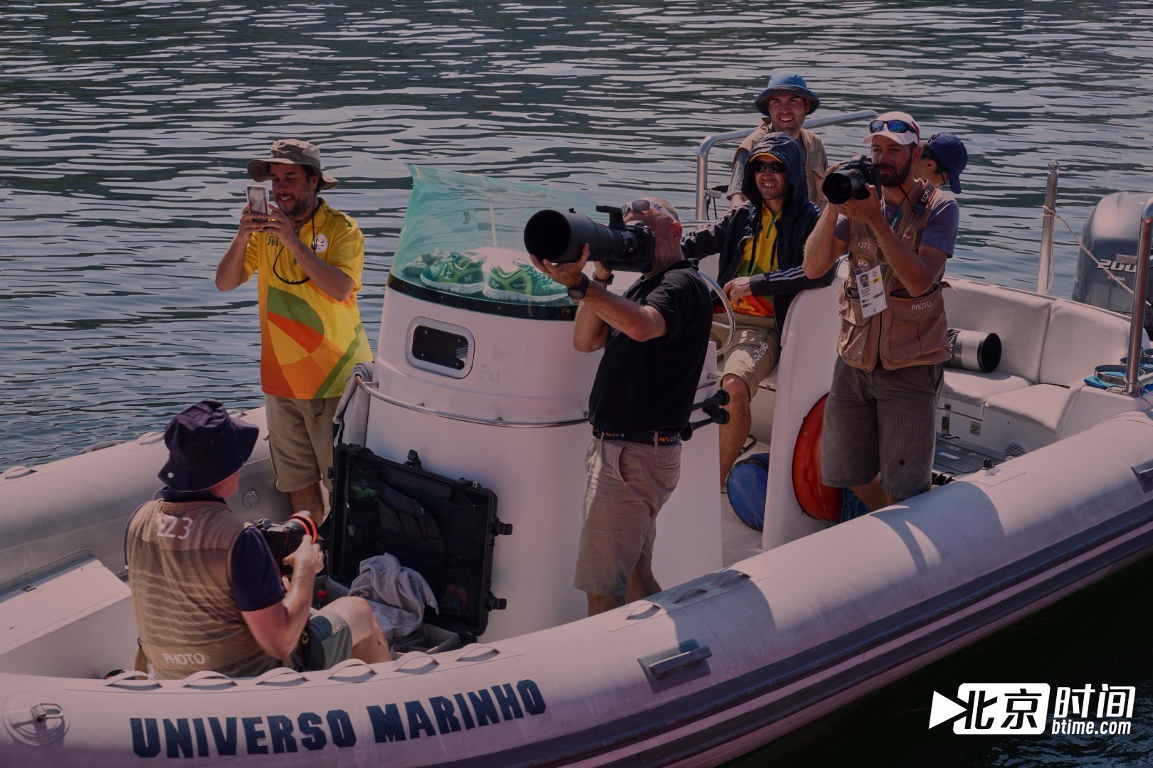 “北京时间号”三体帆船在瓜纳巴拉湾停泊期间,很多媒体记者慕名而来,他们持着“长枪短炮”对北京时间号进行多角度拍摄。他们对这个红色的家伙感到非常有趣,还在蹦床上跳来跳去。这些媒体记者是这次报道奥运会帆船项目的摄影记者,因为当地时间8月17日天气原因帆船项目比赛推迟,他们抽空过来拜访郭川。图为数名记者持“长枪短炮”前来拍摄“北京时间号”三体帆船。