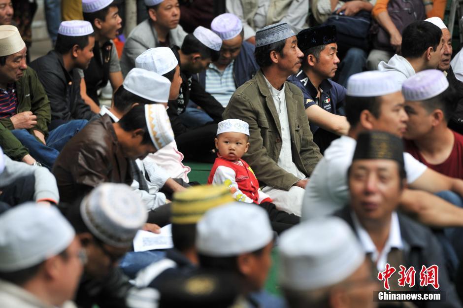 穆罕默德圣人高兴的用右手撕了一块吃了，其余的分给了围观的小孩。图为7月7日，昆明，一个穆斯林男孩参加开斋节。