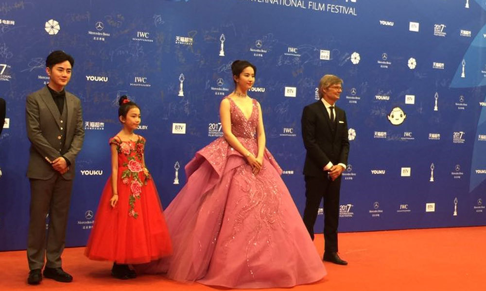 《烽火芳菲》剧组登场，刘亦菲身着深V紫色系礼服，美丽动人。