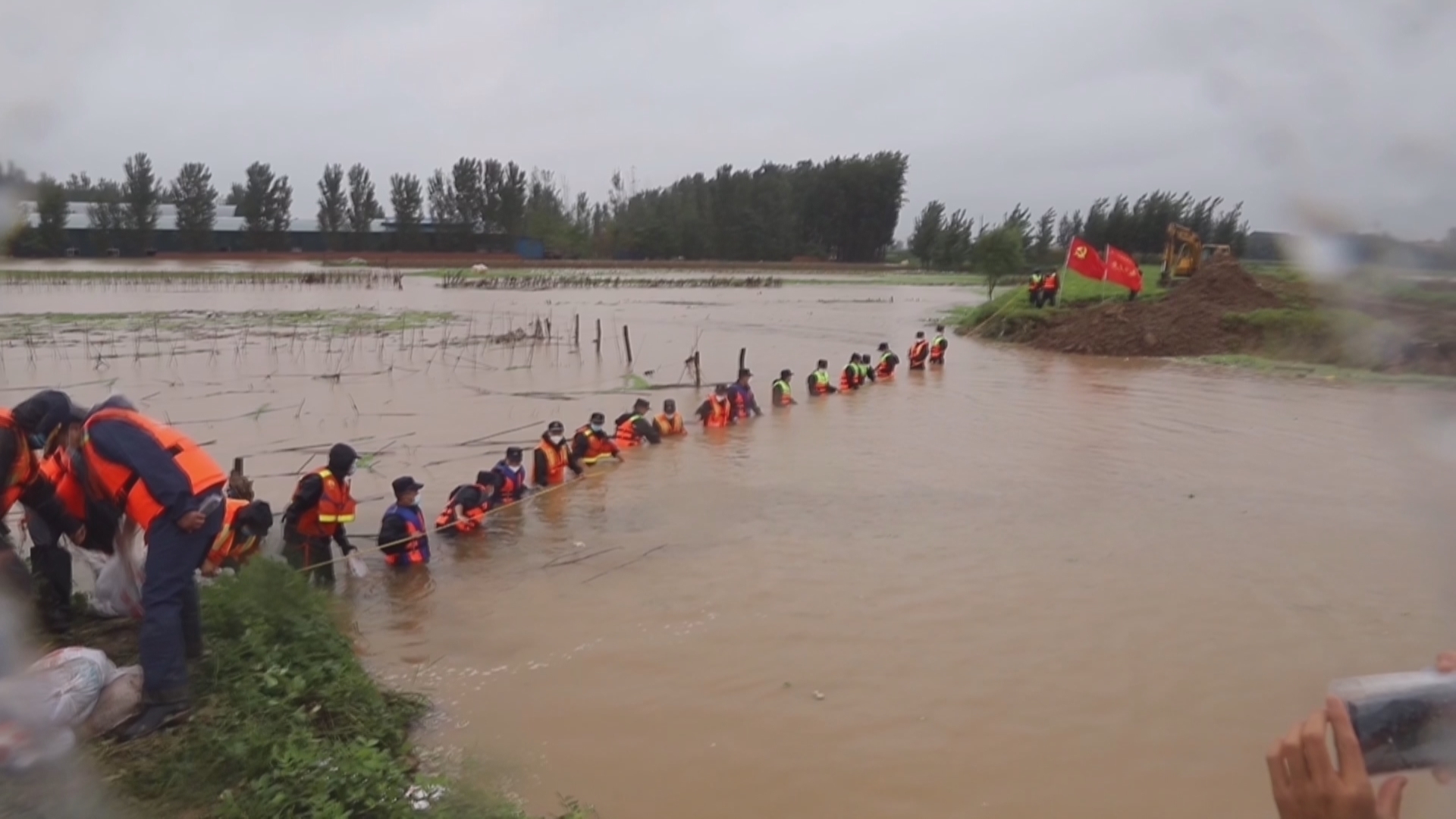 面对河堤上20米长的“大口子” 他们在洪水中筑成人墙