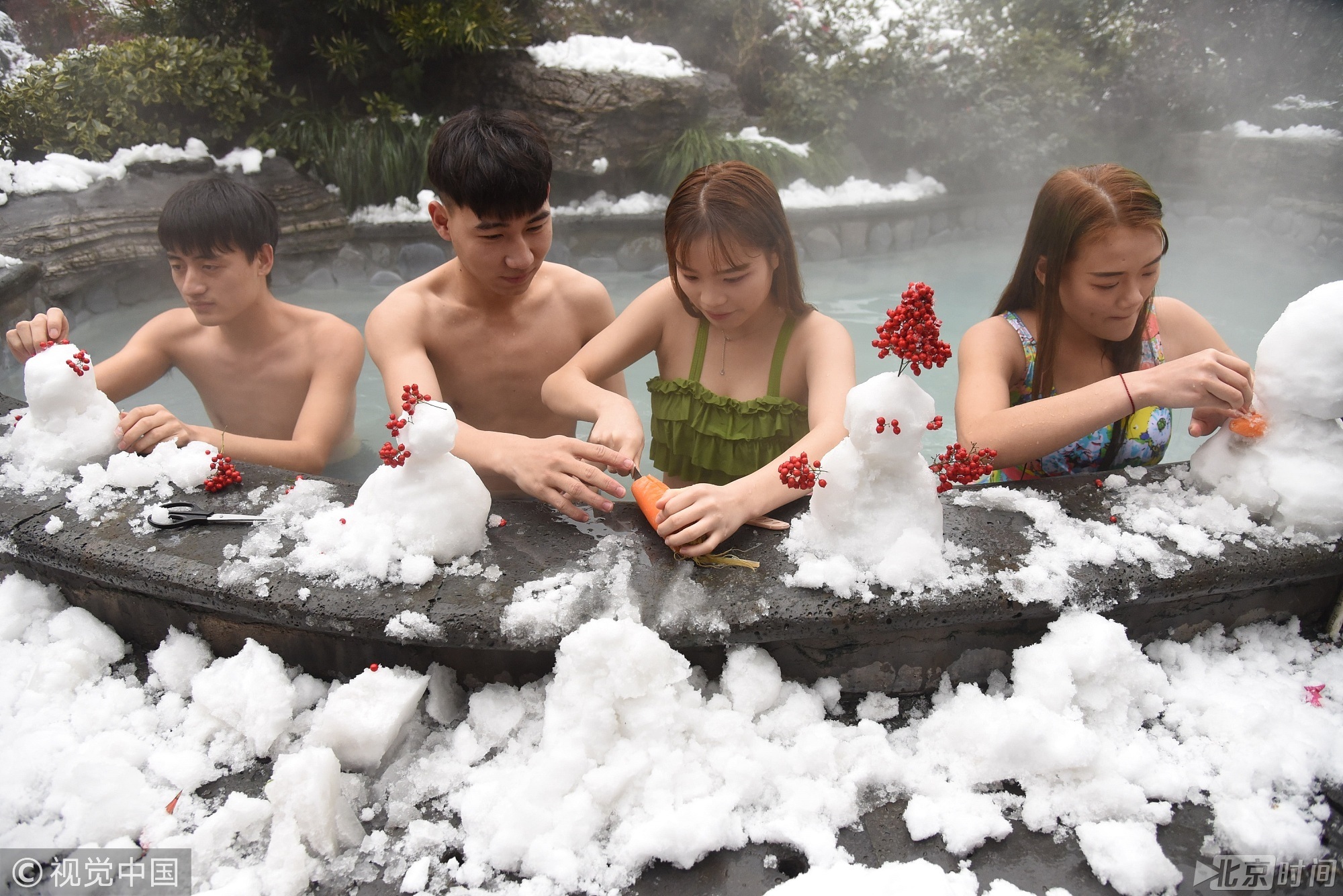 虽然温度有所下降，但并没有影响游客们边泡温泉边玩雪的的好心情。