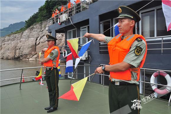 旗语手整齐地打出"欢迎wj3021艇凯旋"的旗语手势.