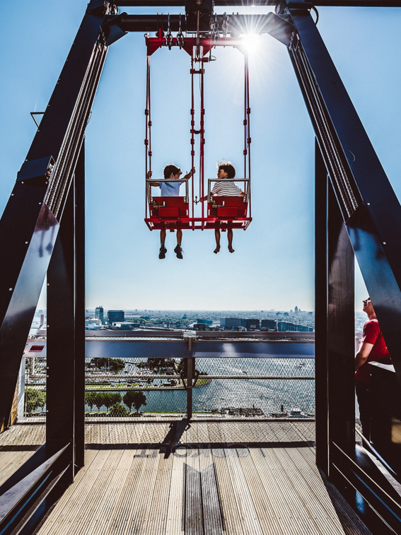 这两位小女孩坐上秋千十分开心。秋千上有安全带，且摇动速度很低，保证了游客在安全的前提下欣赏风景。