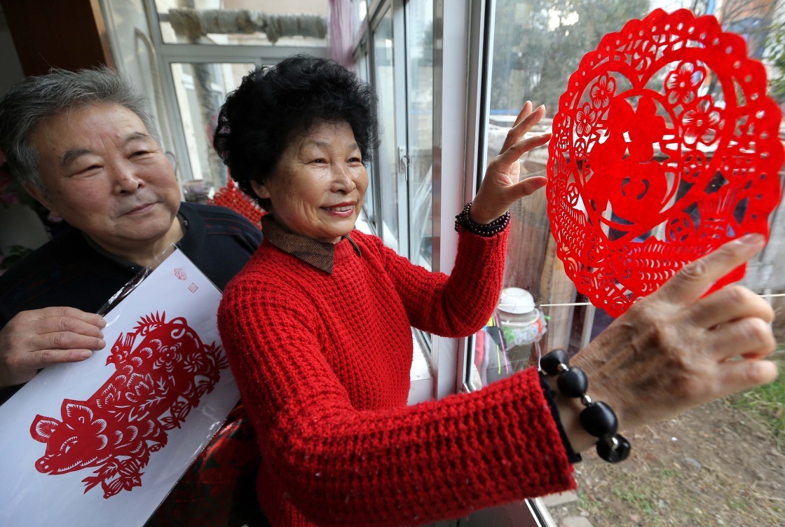 1月28日,江苏省连云港市海州湾街道大港社区剪纸艺人王翠琴(右)和老伴