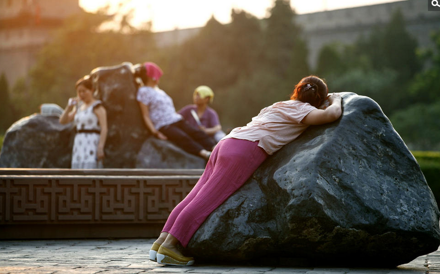 大妈趴在公园热石上"治冬病" 肚皮被烫红