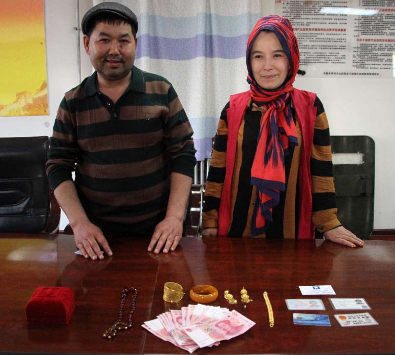 麦合苏木·麦麦提(左)和吐地古丽·依明(右)在失物前合影.