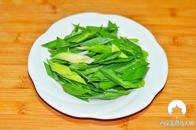 2,在这期间把蒜苗洗净,用菜刀把蒜苗根部拍扁,斜着切段备用