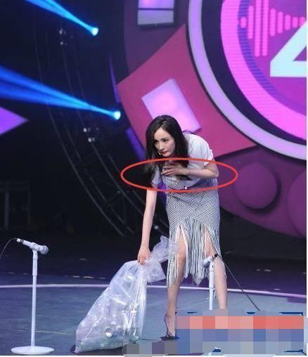 杨幂这是要弯腰了,手捂着胸,可是你也没有穿低胸的衣服啊,捂着干啥呢