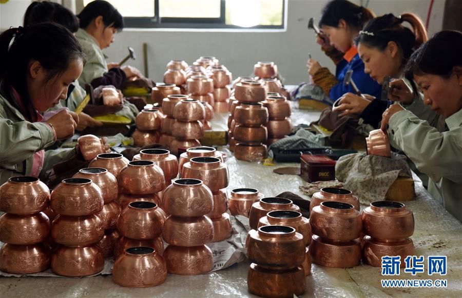 3月21日,技术工人在江西中鼎金属工艺有限公司錾刻铜壶.