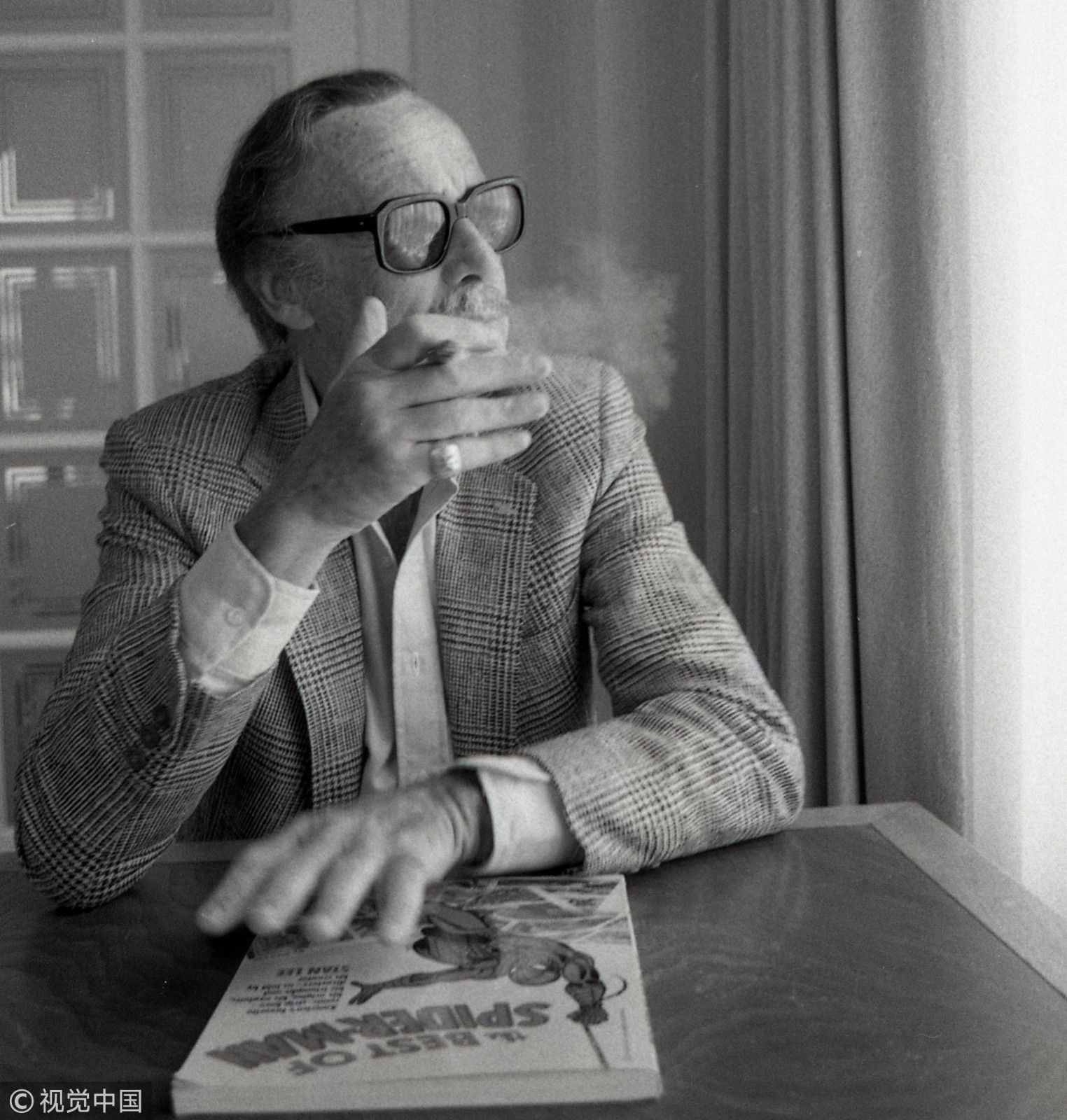 1987年3月27日的黑白旧照曝光,只见斯坦·李在镜头前抽着雪茄看着漫画