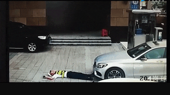 保安为阻止奔驰车进停车场躺车前 司机径直碾过