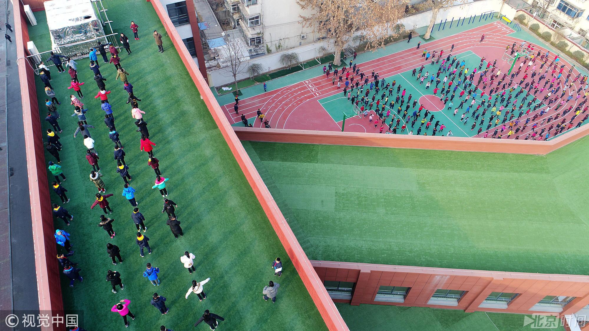 2017年12月13日，山东省济南市，在历山东路北首的济南解放路第二小学，上午10点课间操期间，六年级3个班的学生来到教学楼五楼平台，在大约300平方米的楼顶操场做课间操，其他一至五年级的学生则在校园的操场和过道内做操。据了解，该校教学楼今年下半年重建完成启用，由于校园面积有限，教学楼建设之初就将楼顶平台设计为“空中操场”，地面铺设了人工草地，四周围墙高达1.6米，防止学生攀爬，做课间操期间有老师专门带队看管，确保学生的安全。