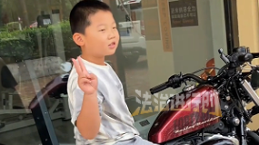 小男孩看到一辆帅气摩托车,忍不住停下想要合影 小男孩看到一辆帅气摩托车,忍不住停下想要合影
