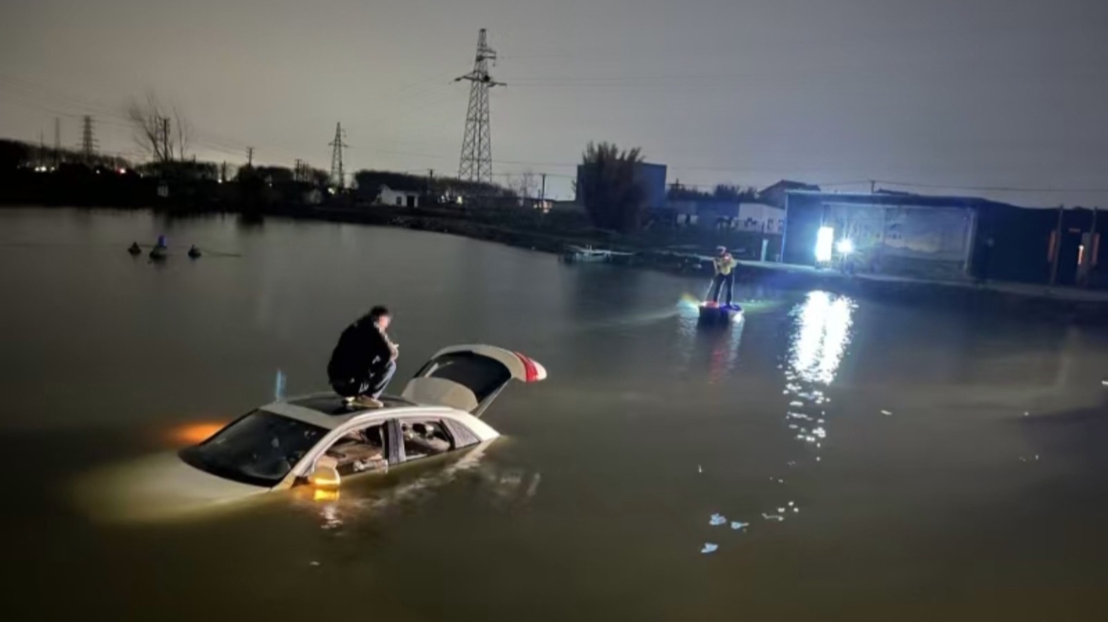 轿车不慎坠河 辅警划船救人 轿车不慎坠河 辅警划船救人