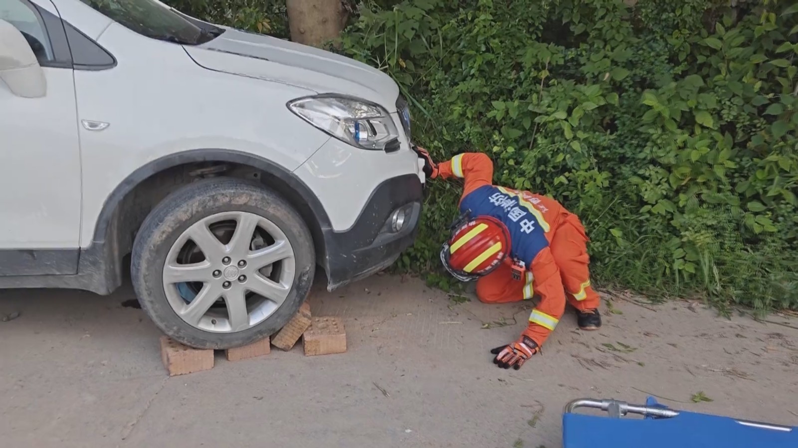 女子被卷车底 众人砖块垫车助脱险 女子被卷车底 众人砖块垫车助脱险