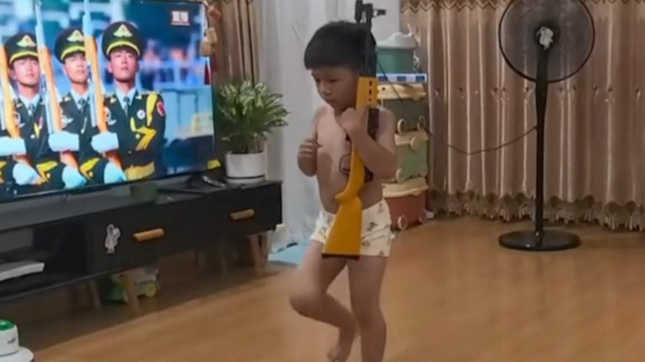 看阅兵回放 小孩哥突然拿起自己的“枪”学起来
