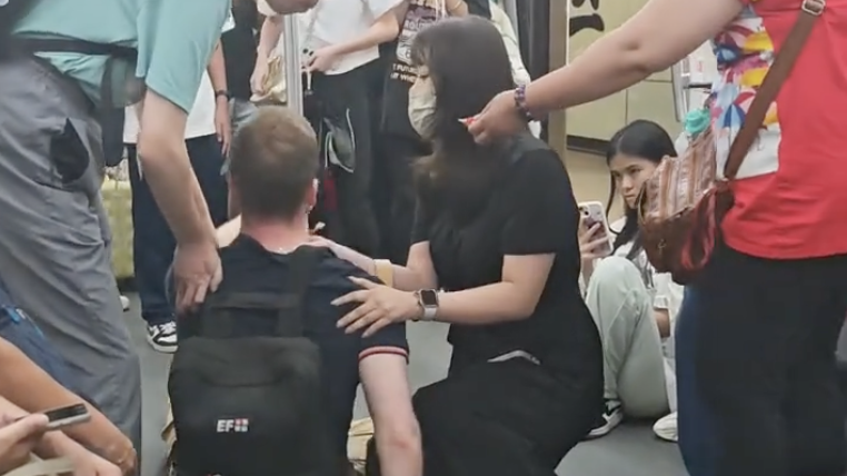 一外籍男子在地铁上因低血糖晕厥倒地，女子立马上前把脉诊断